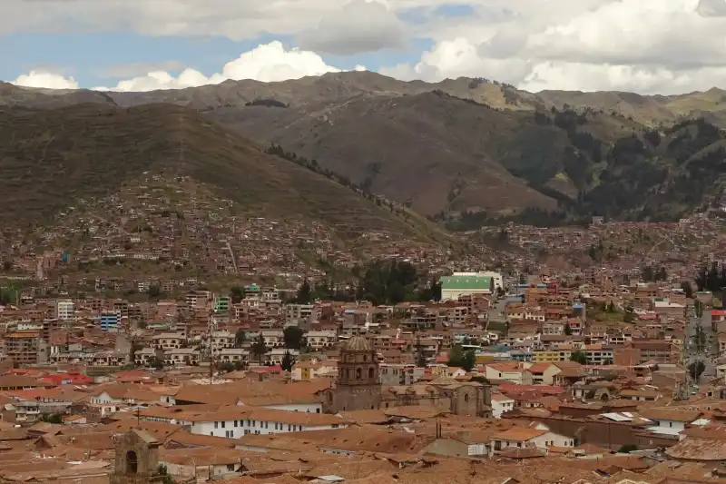 Panoramic view of Cusco's red rooftops surrounded by mountains