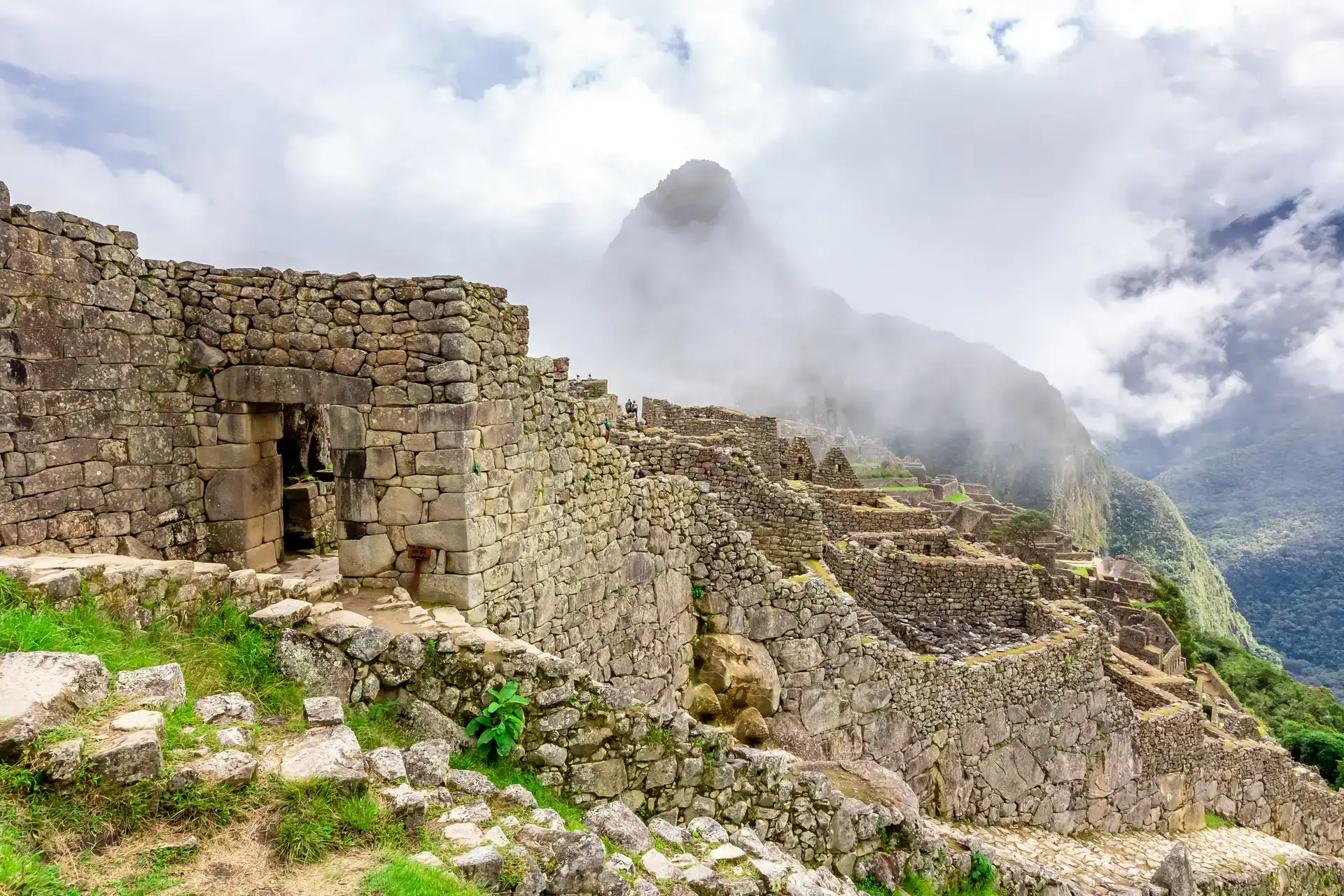 Machu Picchu ruins among the clouds with Huayna Picchu behind